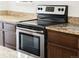 Close up of the stainless steel stove with glass cooktop and light colored granite countertops at 1233 S Yosemite Way # 74, Denver, CO 80247