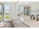 Bright bathroom featuring a double sink vanity with quartz countertops and a glass-enclosed shower at 11487 E Briarwood Cir, Centennial, CO 80112