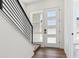 Modern entryway with wood floors, staircase with black railings, and frosted glass door at 11487 E Briarwood Cir, Centennial, CO 80112