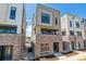 Modern townhome featuring a brick facade, neutral-toned siding, and contemporary window design on a sunny day at 11487 E Briarwood Cir, Centennial, CO 80112