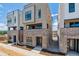 New townhome exterior with modern design, brick base, and neutral siding on a sunny day at 11487 E Briarwood Cir, Centennial, CO 80112