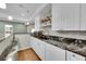 Granite countertop bar in basement with white cabinetry, sink, wine rack and dishwasher at 1706 Ghost Dance Cir, Castle Rock, CO 80108