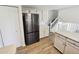 Kitchen with stainless steel refrigerator, white cabinets, and staircase at 16750 E Ada Pl, Aurora, CO 80017