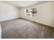 Spacious living room with neutral carpeting and a large window overlooking the neighborhood at 16750 E Ada Pl, Aurora, CO 80017