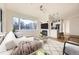 Cozy living room with a large window, modern fireplace, and an open view into the kitchen at 2896 W Riverwalk Cir # A102, Littleton, CO 80123