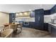 Modern community kitchen with dark cabinetry, breakfast bar, and stainless steel appliances at 130 N Pearl St # 805, Denver, CO 80203