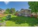 Well-maintained backyard with green lawn, patio, and beautiful landscaping at 6673 S Benton St, Littleton, CO 80123
