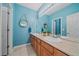 Bright bathroom with dual sinks, light fixtures, and blue colored walls at 6673 S Benton St, Littleton, CO 80123