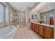 Bright bathroom featuring a soaking tub, walk-in shower, and dual sinks at 6673 S Benton St, Littleton, CO 80123