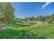 Beautiful community pond with mature trees, wooden bridge and fountain features at 6673 S Benton St, Littleton, CO 80123