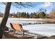 Park bench overlooking frozen pond and snow covered landscape with beautiful trees at 153 S Pierce St, Lakewood, CO 80226