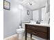 Well-maintained half bath with a dark vanity, framed mirror, and tiled flooring at 4301 S Pierce St # 6D, Littleton, CO 80123