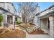 Charming condo exterior featuring landscaped walkway, mature trees, and neutral color scheme at 4301 S Pierce St # 6D, Littleton, CO 80123