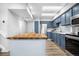 Stylish kitchen featuring stainless steel appliances, light countertops, and blue cabinetry at 4301 S Pierce St # 6D, Littleton, CO 80123