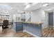 Open-concept kitchen featuring blue cabinets, a breakfast bar, and easy access to the dining and living areas at 4301 S Pierce St # 6D, Littleton, CO 80123