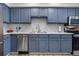 Bright kitchen featuring stainless steel appliances, blue cabinets, and ample counter space at 4301 S Pierce St # 6D, Littleton, CO 80123