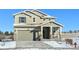 Two-story house with attached garage, covered porch, and snowy yard at 210 Paloma Way, Elizabeth, CO 80107