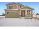 Two-story house with a green exterior, a large garage, and snowy landscaping at 210 Paloma Way, Elizabeth, CO 80107