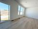 Bright living room with large windows, light hardwood floors, and sliding door access to backyard at 210 Paloma Way, Elizabeth, CO 80107