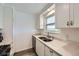 Kitchen with white cabinets and quartz countertops featuring a double sink and stainless steel dishwasher at 1146 Croke Dr, Thornton, CO 80260