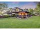 Expansive backyard featuring a large deck, pergola, lush lawn, and mature trees at 10188 Stephen Pl, Highlands Ranch, CO 80130