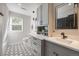 This bathroom features double sinks, black hardware, patterned floor tiles and a window at 10188 Stephen Pl, Highlands Ranch, CO 80130