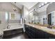 Bathroom with dark cabinets, granite countertops, a chandelier and separate tub and shower at 10188 Stephen Pl, Highlands Ranch, CO 80130