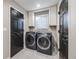 Convenient laundry room with modern front load washer and dryer and storage cabinets at 10188 Stephen Pl, Highlands Ranch, CO 80130