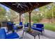 Outdoor seating area in backyard with pergola, blue cushions and lush landscaping at 10188 Stephen Pl, Highlands Ranch, CO 80130