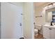 Neat bathroom featuring white fixtures, including a toilet and vanity, next to the front door at 14462 E Mississippi Ave # B, Aurora, CO 80012