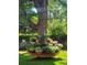 Tranquil garden with a large tree surrounded by a tiered flowerbed brimming with colorful blooms at 3308 S Birch St, Denver, CO 80222