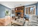 Cozy living room with brick fireplace, hardwood floors, and a comfortable ottoman at 3308 S Birch St, Denver, CO 80222