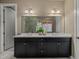 Nicely appointed bathroom featuring double sinks with stone countertops, framed mirror and modern fixtures at 6597 Club Villa Rd, Parker, CO 80134