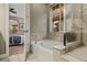 Bathroom with luxurious soaking tub, walk-in shower, and view into the primary bedroom at 6597 Club Villa Rd, Parker, CO 80134