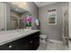 Modern bathroom with a dark vanity, marble countertop, gray walls, and tiled shower at 6597 Club Villa Rd, Parker, CO 80134