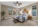 Stylish bedroom with ceiling fan, three windows and decorative wall art above the bed at 6597 Club Villa Rd, Parker, CO 80134