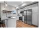 Bright kitchen features white cabinets, stainless steel appliances, light countertops, and wood flooring at 2140 S Ash St # 102, Denver, CO 80222
