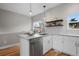Bright kitchen with an eat-in island, stainless appliances, granite countertops and floating wooden shelves at 2140 S Ash St # 102, Denver, CO 80222