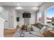 Living room with grey sofa, wood accent wall and a large window at 2140 S Ash St # 102, Denver, CO 80222