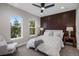 Inviting main bedroom with accent wall, plush carpet, and large windows overlooking trees at 2140 S Ash St # 102, Denver, CO 80222