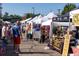 Vibrant outdoor market scene with tents, vendors, and shoppers browsing various goods and flowers at 2140 S Ash St # 102, Denver, CO 80222