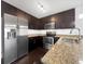 Modern kitchen features stainless steel appliances, granite countertops, and dark wood cabinetry at 1062 Rockhurst Dr # 302, Highlands Ranch, CO 80129