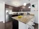 This kitchen features sleek, dark cabinetry, stainless steel appliances, and granite countertops with a breakfast bar at 1062 Rockhurst Dr # 302, Highlands Ranch, CO 80129