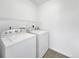 Practical laundry area with white washer and dryer units, with a shelf for additional storage at 1062 Rockhurst Dr # 302, Highlands Ranch, CO 80129
