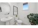 Well lit half bathroom with a pedestal sink, modern fixtures and plants at 7812 W 43Rd Pl, Wheat Ridge, CO 80033