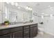 Bathroom featuring a double vanity, large mirror, modern lighting, and a glass-enclosed shower at 7812 W 43Rd Pl, Wheat Ridge, CO 80033