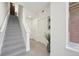 Hallway leading upstairs with wood stairs, white walls, and modern lighting at 7812 W 43Rd Pl, Wheat Ridge, CO 80033