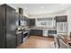 Modern kitchen with dark cabinetry, stainless steel appliances, and hardwood floors at 7812 W 43Rd Pl, Wheat Ridge, CO 80033