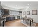 Modern kitchen featuring stainless steel appliances, dark cabinets and a dining area with natural light at 7812 W 43Rd Pl, Wheat Ridge, CO 80033