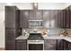 This kitchen boasts dark cabinets, light countertops, stainless steel appliances, and wood floors at 7812 W 43Rd Pl, Wheat Ridge, CO 80033